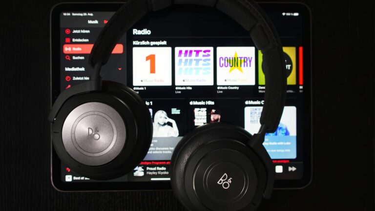 headphones and tablet with music library on screen