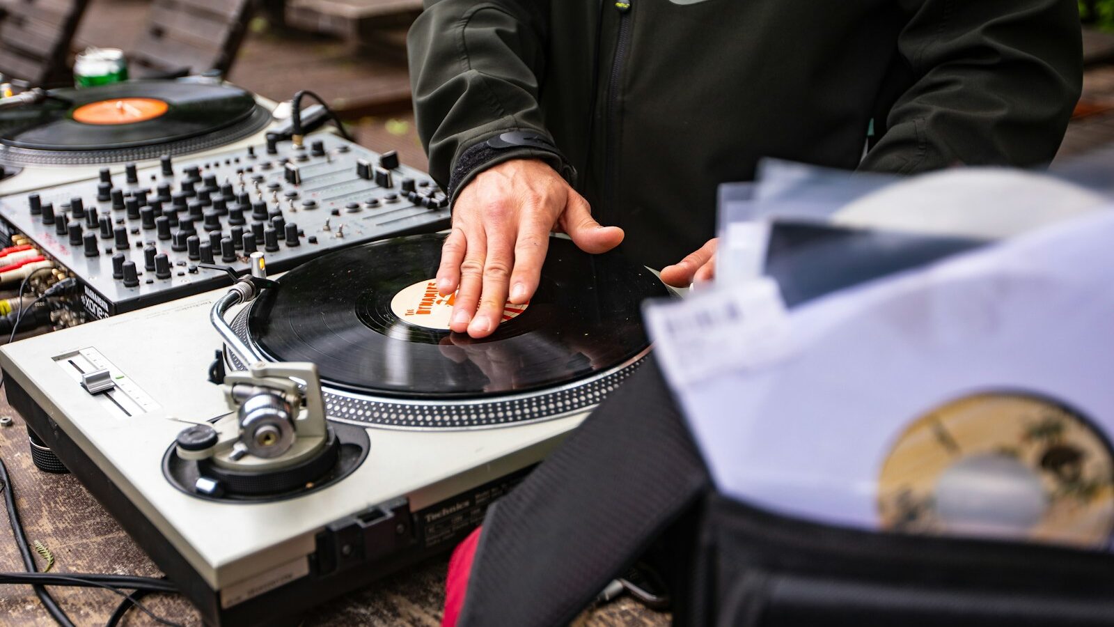 person in black jacket holding brown wooden chopping board