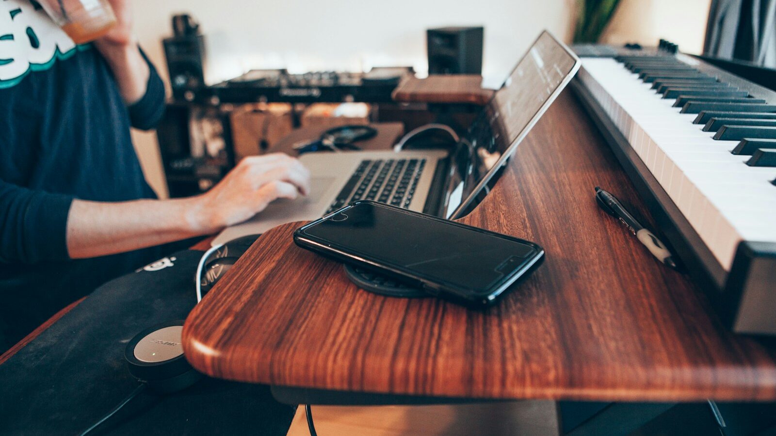 black Android smartphone beside MacBook Pro on top of brown table