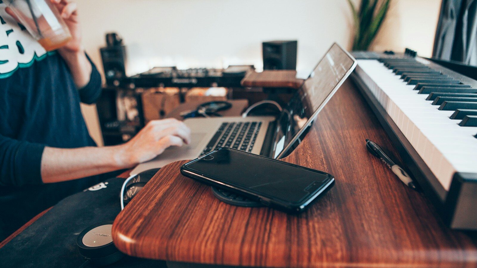 black Android smartphone beside MacBook Pro on top of brown table