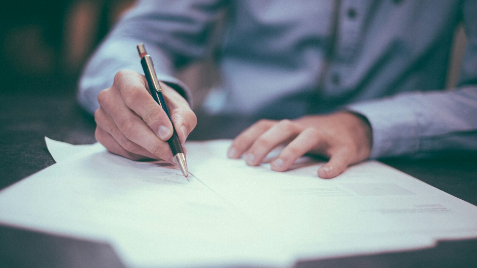 man writing on paper