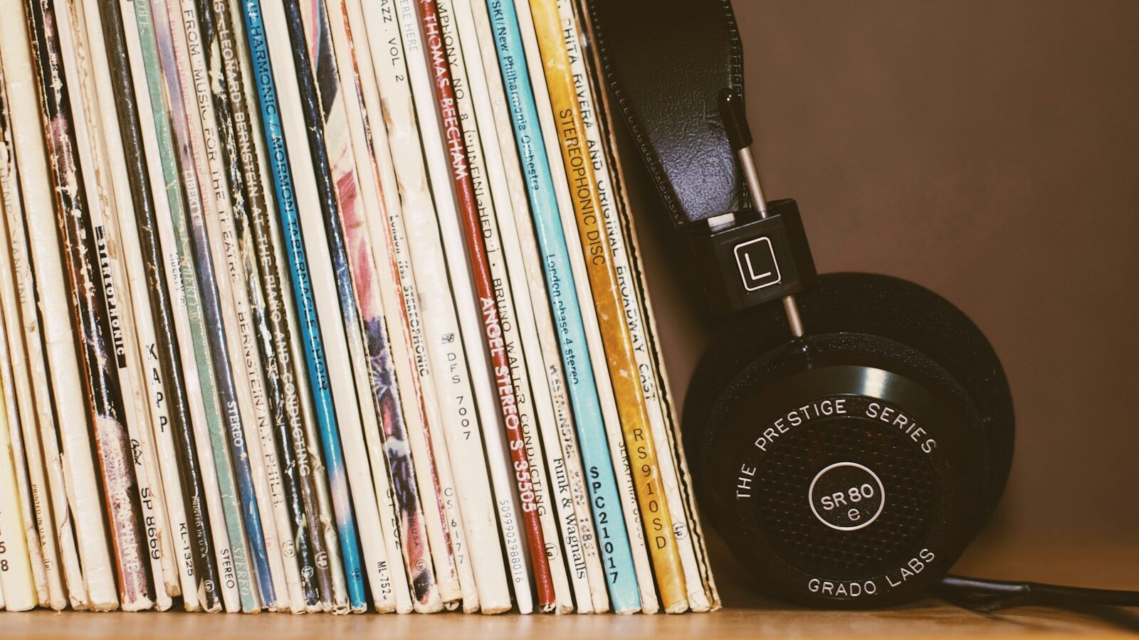 wireless headphones leaning on vinyl records