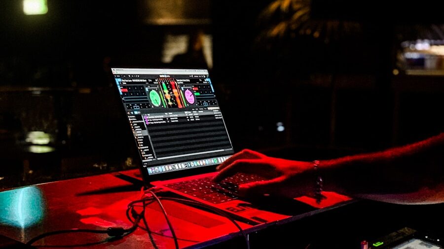 a dj mixing music in front of a laptop