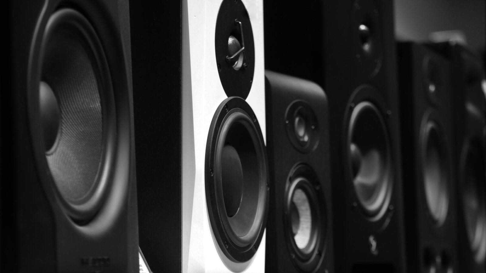 black and gray speakers on brown wooden table