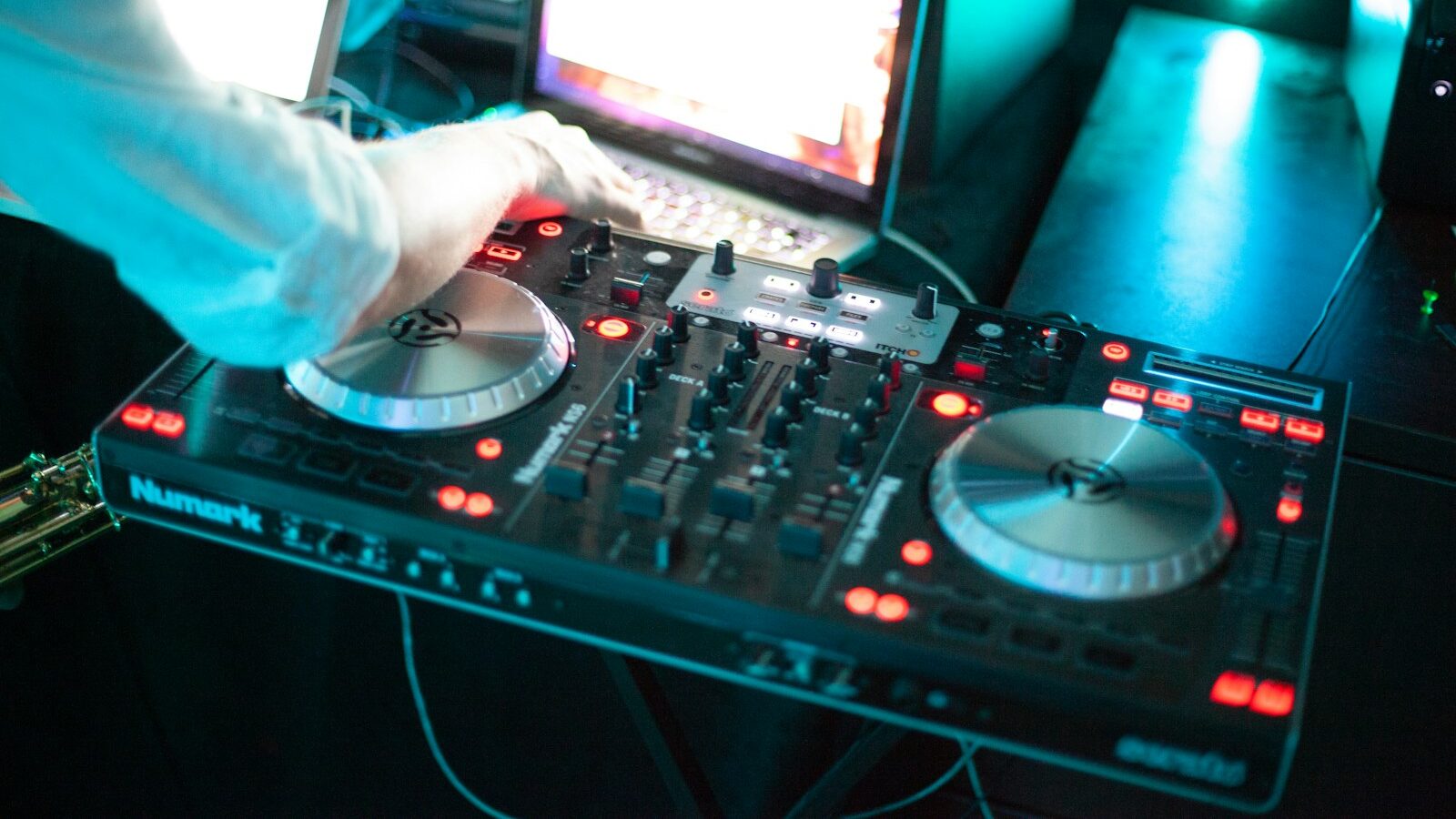 person playing dj controller with audio mixer