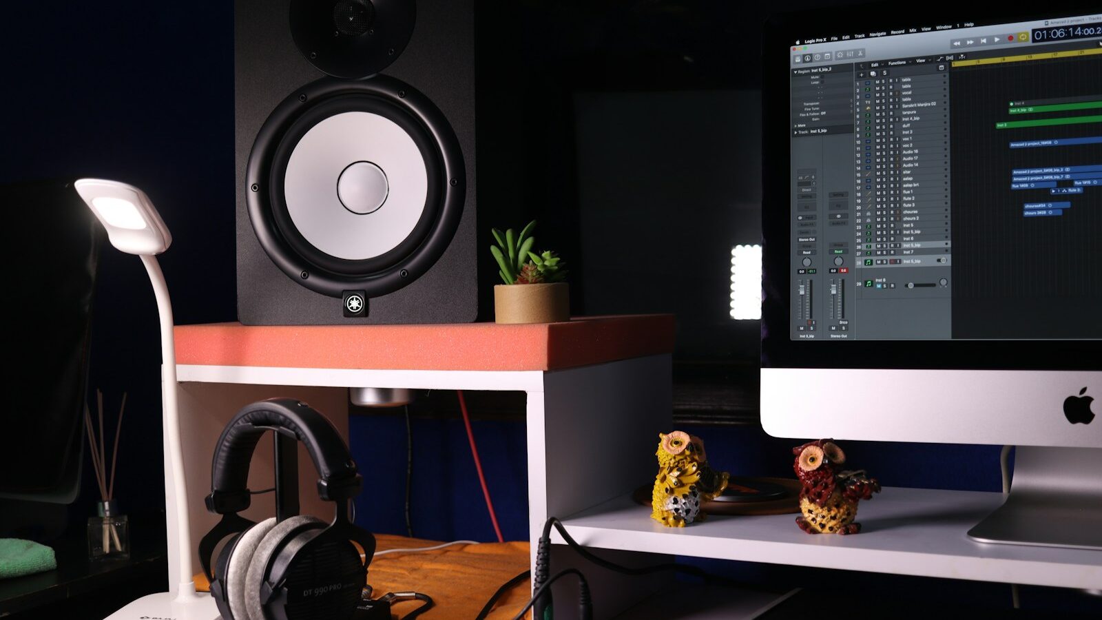 a desk with a monitor, headphones and a keyboard