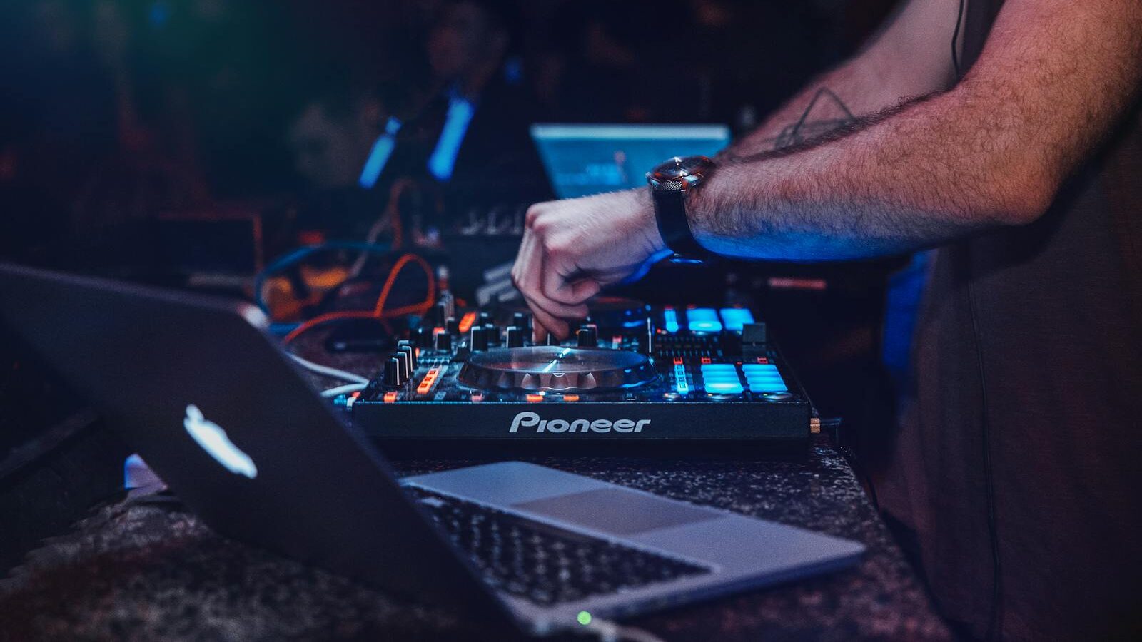 DJ performing with mixer in a vibrant nightclub setting. Perfect for entertainment and technology themes.